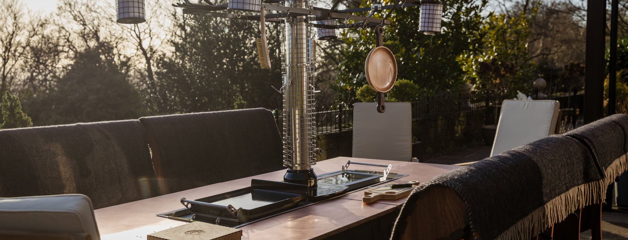 Dining table set for four with chairs and a view of trees and sky.