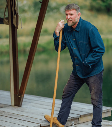 Guy Ritchie standing on a wooden dock beside a WildKitchen.